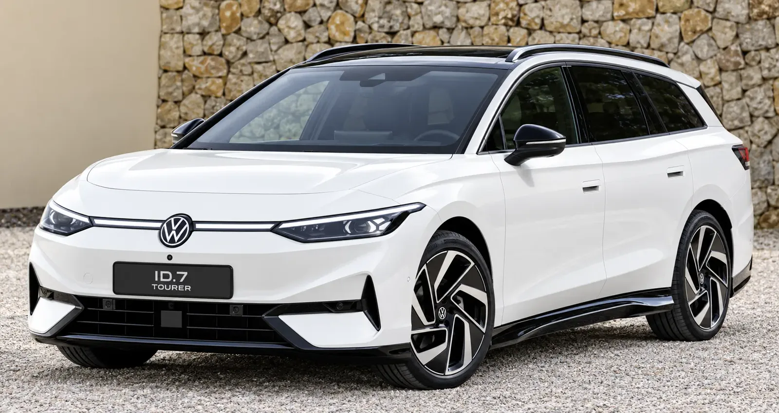 Weißer Volkswagen ID.7 Tourer vor Steinmauer