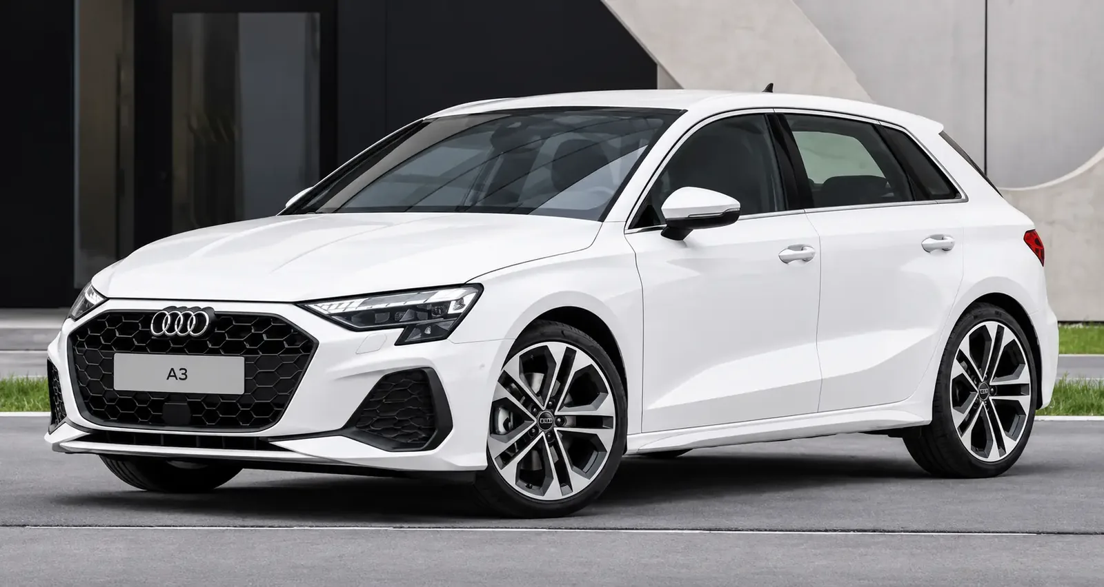 Weißer Audi A3 Sportback vor moderner Architektur